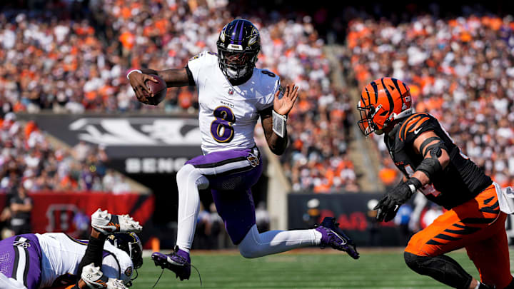 Baltimore Ravens quarterback Lamar Jackson (8) leaps away from Cincinnati Bengals defensive end Sam Hubbard (94) on a keeper in the first quarter of the NFL Week 5 game between the Cincinnati Bengals and Baltimore Ravens at Paycor Stadium in downtown Cincinnati on Sunday, Oct. 6, 2024. The Bengals led 17-14 at halftime.