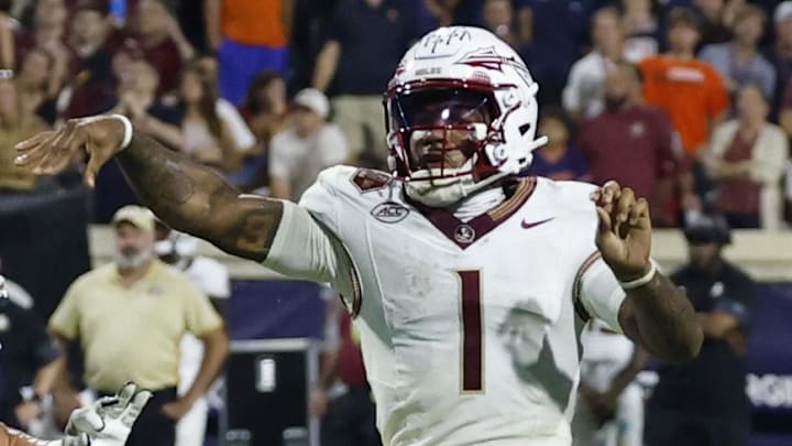 Sep 26, 2025; Charlottesville, Virginia, USA; Florida State Seminoles quarterback Tommy Castellanos (1) throws a touchdown pass on fourth down as Virginia Cavaliers defensive lineman Daniel Rickert (52) chases in the final minute of the fourth quarter at Scott Stadium. Mandatory Credit: Geoff Burke-Imagn Images