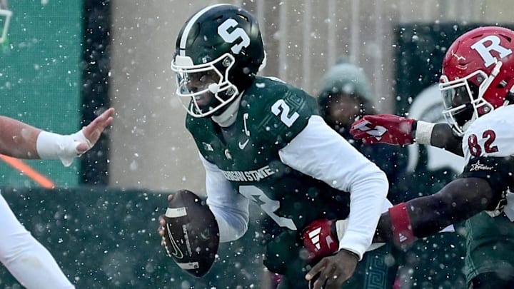 Nov 30, 2024; East Lansing, Michigan, USA;  Michigan State Spartans quarterback Aidan Chiles (2) gets caught behind the line by Rutgers Scarlet Knights defensive lineman Jordan Walker (82) during the first quarter at Spartan Stadium. Mandatory Credit: Dale Young-Imagn Images