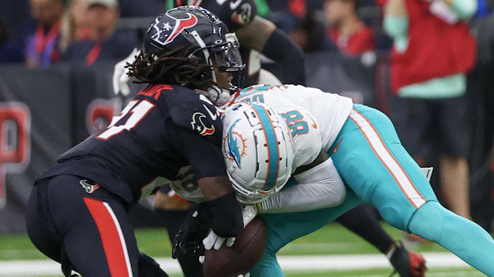 Dec 15, 2024; Houston, Texas, USA; Miami Dolphins wide receiver Grant DuBose (88) is tackled by Houston Texans safety Calen Bullock (21) in the third quarter at NRG Stadium. Miami Dolphins wide receiver Grant DuBose (88) was injured on the play and had to leave the game. Mandatory Credit: Thomas Shea-Imagn Images