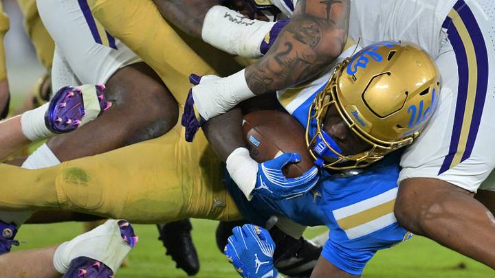 Nov 22, 2025; Pasadena, California, USA; UCLA Bruins running back Anthony Woods (6) is brought down by Washington Huskies linebacker Deven Bryant (17) during the first half at the Rose Bowl. Mandatory Credit: Jayne Kamin-Oncea-Imagn Images Nov 22, 2025; Pasadena, California, USA; UCLA Bruins running back Anthony Woods (6) is brought down by Washington Huskies linebacker Deven Bryant (17) during the first half at the Rose Bowl. Mandatory Credit: Jayne Kamin-Oncea-Imagn Images