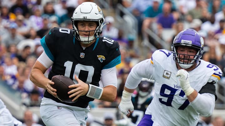 Nov 10, 2024; Jacksonville, Florida, USA; Jacksonville Jaguars quarterback Mac Jones (10) runs the ball against Minnesota Vikings defensive lineman Harrison Phillips (97) in the second quarter at EverBank Stadium. Mandatory Credit: Jeremy Reper-Imagn Images