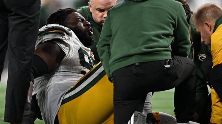Green Bay Packers defensive tackle Devonte Wyatt (95) is checked by trainers during Thursday's game against the Lions.