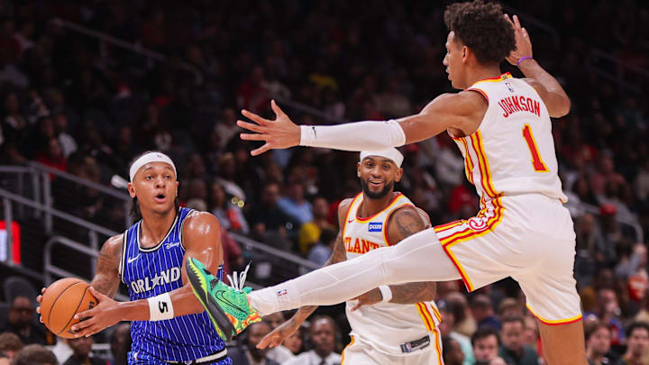 Nov 4, 2025; Atlanta, Georgia, USA; Orlando Magic forward Paolo Banchero (5) is defended by Atlanta Hawks guard Nickeil Alexander-Walker (7) and forward Jalen Johnson (1) in the second quarter at State Farm Arena. Mandatory Credit: Brett Davis-Imagn Images