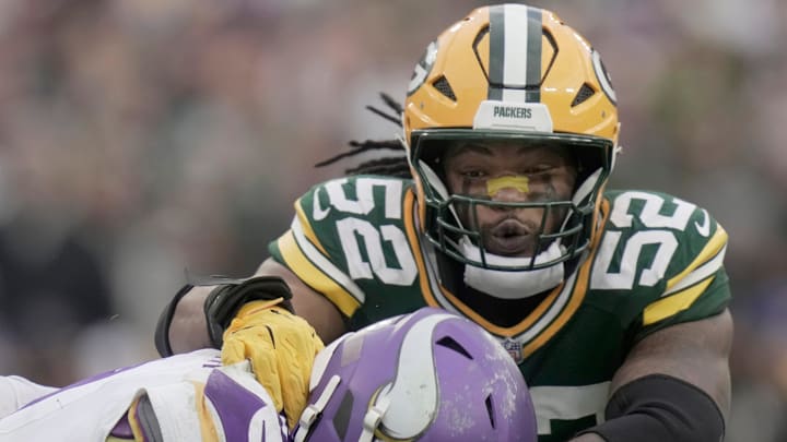 Minnesota Vikings' J.J. McCarthy (9) evades a sack by Green Bay Packers defensive end Rashan Gary.