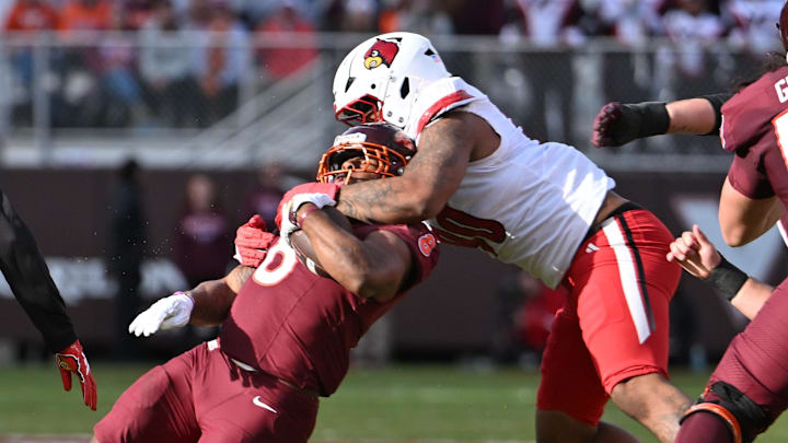 Nov 1, 2025; Blacksburg, Virginia, USA; Louisville Cardinals defensive lineman Rene Konga (90) tackles Virginia Tech Hokies running back Terion Stewart (8) during the second quarter at Lane Stadium. Mandatory Credit: Brian Bishop-Imagn Images