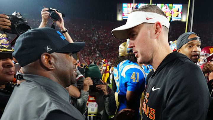Nov 29, 2025; Los Angeles, California, USA; UCLA Bruins interim coach Tim Skipper (left) shakes hands with Southern California Trojans head coach Lincoln Riley after the game at United Airlines Field at Los Angeles Memorial Coliseum. Mandatory Credit: Kirby Lee-Imagn Images