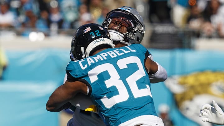 Dec 31, 2023; Jacksonville, Florida, USA; Jacksonville Jaguars corner back Tyson Campbell (32) tackles Carolina Panthers wide receiver Jonathan Mingo (15) during the first quarter at EverBank Stadium. Mandatory Credit: Morgan Tencza-Imagn Images