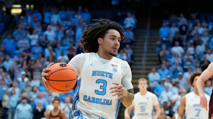 Nov 4, 2024; Chapel Hill, North Carolina, USA; North Carolina Tar Heels guard Elliot Cadeau (3) on the fast break as Elon Phoenix forward Isaac Harrell (12) defends in the second half at Dean E. Smith Center. Mandatory Credit: Bob Donnan-Imagn Images