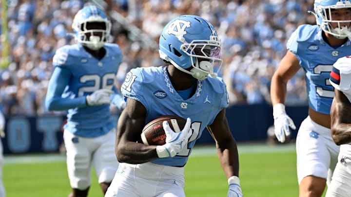 Sep 13, 2025; Chapel Hill, North Carolina, USA; North Carolina Tar Heels defensive back Kaleb Cost (21) runs as Richmond Spiders wide receiver Ja'Vion Griffin (5) defends in the second quarter at Kenan Stadium. The play was later called back due to a penalty. Mandatory Credit: Bob Donnan-Imagn Images