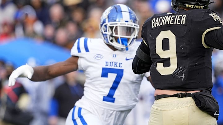 Nov 30, 2024; Winston-Salem, North Carolina, USA;  Wake Forest Demon Deacons quarterback Hank Bachmeier (9) is pressured by Duke Blue Devils defensive end Vincent Anthony Jr. (7) during the second half at Allegacy Federal Credit Union Stadium. Mandatory Credit: Jim Dedmon-Imagn Images