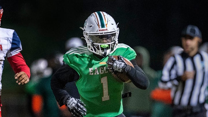 Atlantic running back Deandre Desinor, right, runs past Miramar's Jakhari Reynolds, left, and Samuel A. Griffin on November 22, 2024, in Delray Beach, Florida.