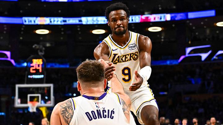 Nov 2, 2025; Los Angeles, California, USA; Los Angeles Lakers guard Bronny James (9) helps guard Luka Doncic (77) up from the floor against the Miami Heat during the second half at Crypto.com Arena. Mandatory Credit: Jonathan Hui-Imagn Images