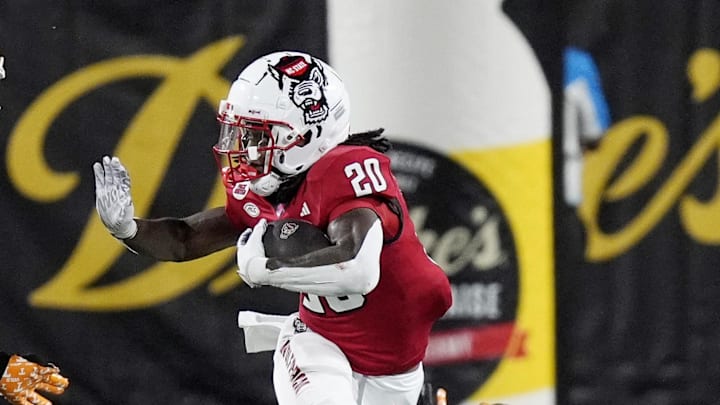 Sep 7, 2024; Charlotte, North Carolina, USA; North Carolina State Wolfpack running back Hollywood Smothers (20) runs with the ball as Tennessee Volunteers defensive lineman Omari Thomas (21) defends during the second quarter at the Dukes Mayo Classic at Bank of America Stadium. Mandatory Credit: Jim Dedmon-Imagn Images Sep 7, 2024; Charlotte, North Carolina, USA; North Carolina State Wolfpack running back Hollywood Smothers (20) runs with the ball as Tennessee Volunteers defensive lineman Omari Thomas (21) defends during the second quarter at the Dukes Mayo Classic at Bank of America Stadium. Mandatory Credit: Jim Dedmon-Imagn Images