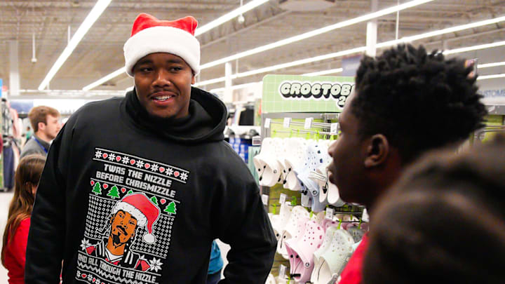 Jacksonville Jaguars defensive end Travon Walker, left, helps Deion Blackman, 13, center, pick out some socks while taking part in Shop with a Jaguar at the Academy Sports in Jacksonville, Fla. Monday December 15, 2025. [Doug Engle/Florida Times-Union]