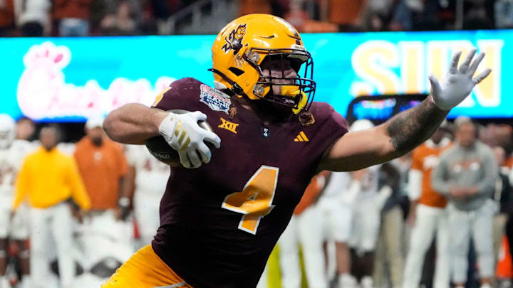 Arizona State running back Cam Skattebo (4) escapes a tackle by Texas defensive lineman Alfred Collins (95) during the fourth quarter in the Chick-fil-A Peach Bowl in Atlanta on Wednesday, Jan. 1, 2025.