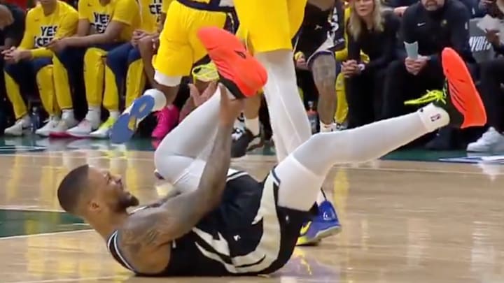 Milwaukee Bucks' Damian Lillard grabs at his leg after suffering an injury vs. the Indiana Pacers.