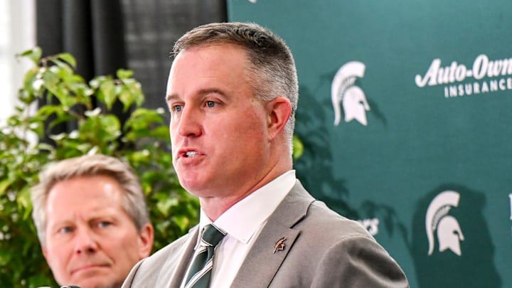 Michigan State's new football coach Pat Fitzgerald, right,, talks during his introductory press conference on Tuesday, Dec. 2, 2025, at the Tom Izzo Football Building in East Lansing. At left, MSU Athletic Director J Batt and MSU President Kevin Guskiewicz, center, look on.