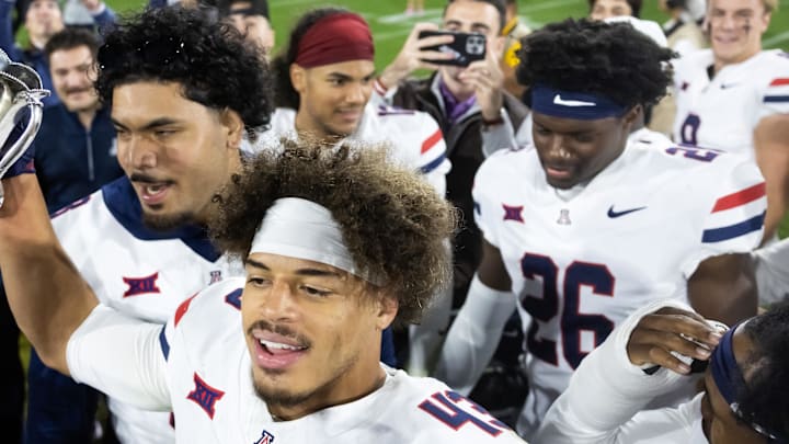 Nov 28, 2025; Tempe, Arizona, USA; Arizona Wildcats defensive back Dalton Johnson (43) celebrates with the Territorial Cup trophy after defeating the Arizona State Sun Devils in the 99th Territorial Cup at Mountain America Stadium. Mandatory Credit: Mark J. Rebilas-Imagn Images Nov 28, 2025; Tempe, Arizona, USA; Arizona Wildcats defensive back Dalton Johnson (43) celebrates with the Territorial Cup trophy after defeating the Arizona State Sun Devils in the 99th Territorial Cup at Mountain America Stadium. Mandatory Credit: Mark J. Rebilas-Imagn Images