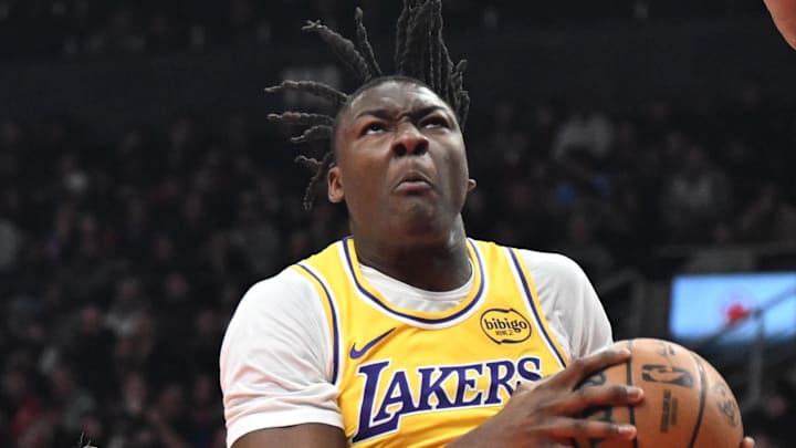 Dec 4, 2025; Toronto, Ontario, CAN; Los Angeles Lakers forward Adou Thiero (1) drives to the basket between Toronto Raptors forwards Gradey Dick (1) and Scottie Barnes (4) in the first half at Scotiabank Arena. Mandatory Credit: Dan Hamilton-Imagn Images