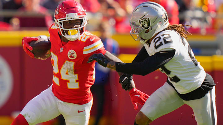 Oct 19, 2025; Kansas City, Missouri, USA; Kansas City Chiefs running back Brashard Smith (24) carries the ball defended by Las Vegas Raiders cornerback Eric Stokes (22) during the fourth quarter of the game at GEHA Field at Arrowhead Stadium.