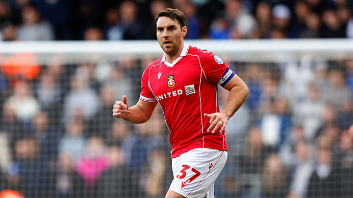 ผู้เล่นหลักของเร็กซ์แฮมสู้ต่อด้วยรองเท้าสตั๊ดที่ไม่เข้าคู่กัน เพื่อหนุนการผลักดันเลื่อนชั้นของสโมสร