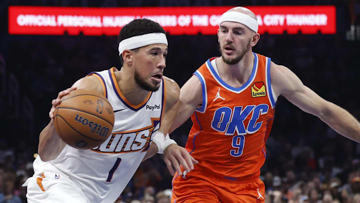 Nov 28, 2025; Oklahoma City, Oklahoma, USA; Phoenix Suns guard Devin Booker (1) drives past Oklahoma City Thunder guard Alex Caruso (9) during the second quarter at Paycom Center. Mandatory Credit: Alonzo Adams-Imagn Images