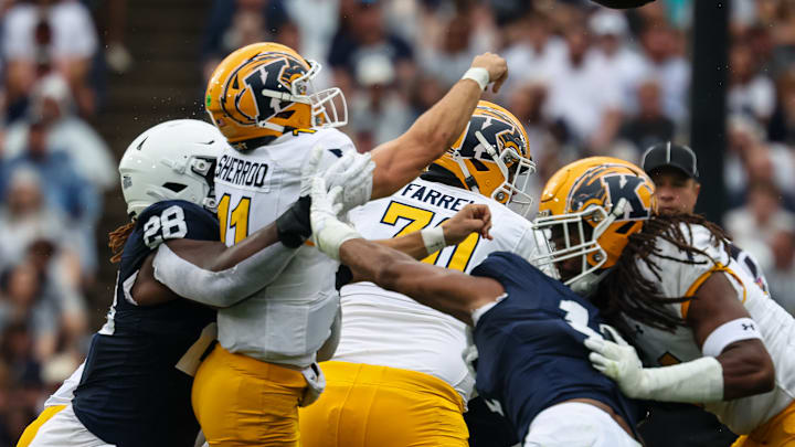 JD Sherrod #11 of the Kent State Golden Flashes is hit by Zane Durant #28 of the Penn State Nittany Lions as he attempts a pass during the first half at Beaver Stadium on September 21, 2024 in State College, Pennsylvania.