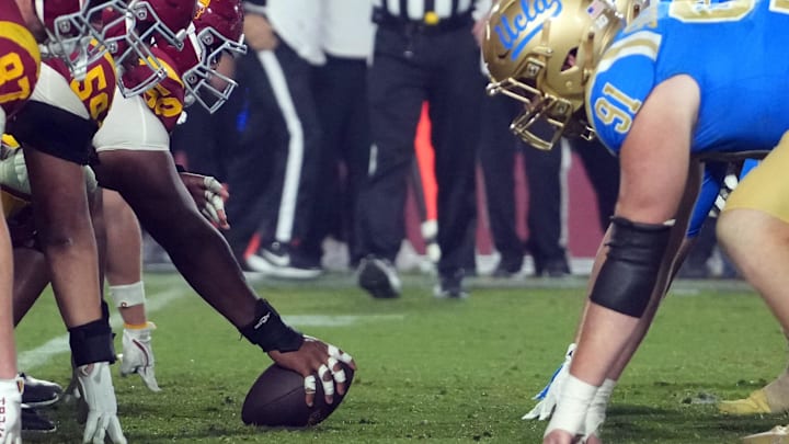 Nov 29, 2025; Los Angeles, California, USA; Helmets at the line of scrimmage as Southern California Trojans offensive lineman J'Onre Reed (50) snaps the ball against the UCLA Bruins in the second half at United Airlines Field at Los Angeles Memorial Coliseum. Mandatory Credit: Kirby Lee-Imagn Images Nov 29, 2025; Los Angeles, California, USA; Helmets at the line of scrimmage as Southern California Trojans offensive lineman J'Onre Reed (50) snaps the ball against the UCLA Bruins in the second half at United Airlines Field at Los Angeles Memorial Coliseum. Mandatory Credit: Kirby Lee-Imagn Images