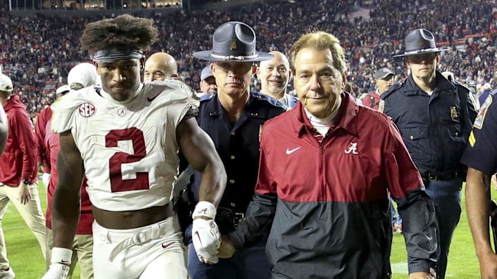 Nov 25, 2023; Auburn, Alabama, USA;  Alabama Crimson Tide defensive back Caleb Downs (2) and head coach Nick Saban grasp hands as they walk off the field following a victory over the Auburn Tigers at Jordan-Hare Stadium. Alabama won 27-24. Mandatory Credit: Gary Cosby Jr.-Imagn Images