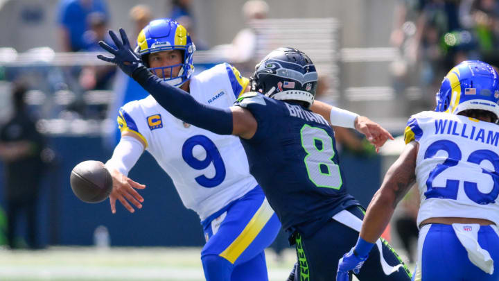 Sep 10, 2023; Seattle, Washington, USA; Los Angeles Rams quarterback Matthew Stafford (9) throws the ball away before being tackled by Seattle Seahawks cornerback Coby Bryant (8) during the first half at Lumen Field. Mandatory Credit: Steven Bisig-USA TODAY Sports