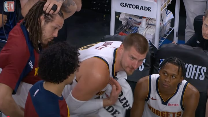Nikola Jokic reacts to the Nuggets blowout loss on the bench.