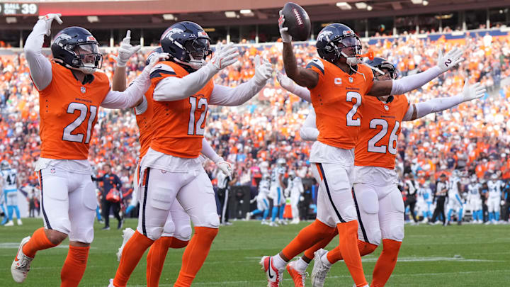 Oct 27, 2024; Denver, Colorado, USA; Denver Broncos cornerback Pat Surtain II (2) celebrates his interception with cornerback Riley Moss (21) and linebacker Kwon Alexander (12) and safety Devon Key (26) in the third quarter against the Carolina Panthers at Empower Field at Mile High. 
