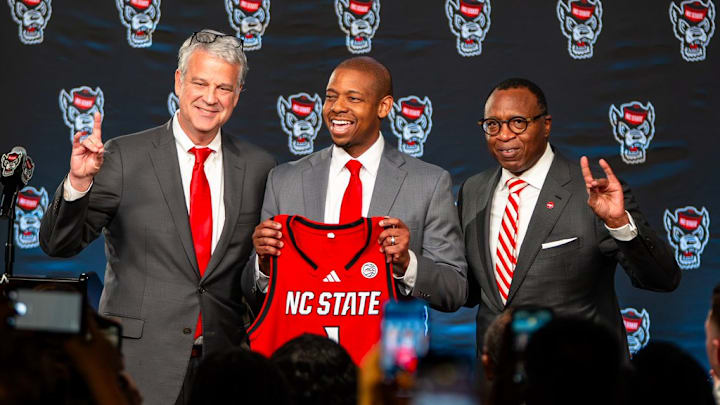 NC State AD Boo Corrigan, men's basketball coach Justin Gainey and Chancellor Kevin Howell pose at Gainey's introductory press conference at the Lenovo Center on Wednesday, April 1, 2026. 