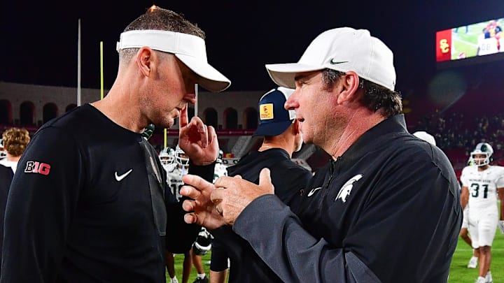 Sep 20, 2025; Los Angeles, California, USA; Southern California Trojans head coach Lincoln Riley meets with Michigan State Spartans head coach Jonathan Smith following the game at the Los Angeles Memorial Coliseum. Mandatory Credit: Gary A. Vasquez-Imagn Images