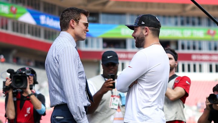 Sep 29, 2024; Tampa, Florida, USA;   Fox NFL broadcaster and former NFL quarterback Tom Brady speaks to Tampa Bay Buccaneers quarterback Baker Mayfield (6) before a game against the Philadelphia Eagles at Raymond James Stadium. Mandatory Credit: Nathan Ray Seebeck-Imagn Images