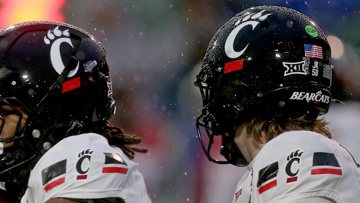 Jan 2, 2026; Memphis, TN, USA; Cincinnati Bearcats quarterback Brady Lichtenberg (16) hands the ball off to Cincinnati Bearcats running back Zion Johnson (13) during the first quarter against the Navy Midshipmen at Simmons Bank Liberty Stadium. Mandatory Credit: Petre Thomas-Imagn Images