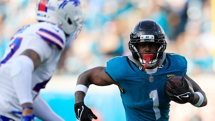 Jacksonville Jaguars running back Travis Etienne Jr. (1) rushes for yards against Buffalo Bills cornerback Christian Benford (47) during the fourth quarter of an NFL football AFC Wild Card playoff matchup, Sunday, Jan. 11, 2026, in Jacksonville, Fla. The Bills defeated the Jaguars 27-24. [Corey Perrine/Florida Times-Union]