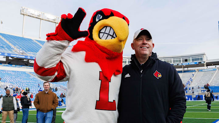Nov 30, 2024; Lexington, Kentucky, USA; Louisville Cardinals head coach Jeff Brohm poses for a photo with the Cardinal mascot after the game against the Kentucky Wildcats at Kroger Field. Mandatory Credit: Jordan Prather-Imagn Images