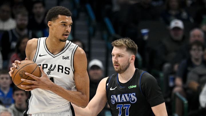 Feb 14, 2024; Dallas, Texas, USA; San Antonio Spurs center Victor Wembanyama (1) looks to move the ball past Dallas Mavericks guard Luka Doncic (77) during the fist quarter at the American Airlines Center. Mandatory Credit: Jerome Miron-Imagn Images