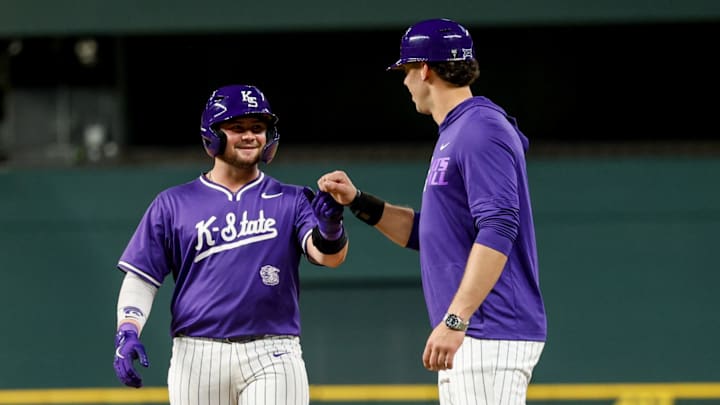 Kansas State Wildcats' Bear Madliak gives fist bump to first base coach during Sunday's game against Michigan. Kansas State Wildcats' Bear Madliak gives fist bump to first base coach during Sunday's game against Michigan.