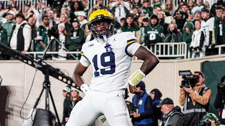 Michigan quarterback Bryce Underwood celebrates a touchdown by posing as the Paul Bunyan Trophy against Michigan State during the first half at Spartan Stadium in East Lansing on Saturday, October 25, 2025.