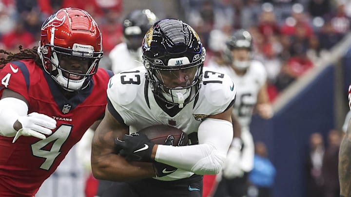 Nov 26, 2023; Houston, Texas, USA; Jacksonville Jaguars wide receiver Christian Kirk (13) runs with the ball after a reception as Houston Texans cornerback Tavierre Thomas (4) attempts to make a tackle during the first quarter at NRG Stadium. Mandatory Credit: Troy Taormina-Imagn Images
