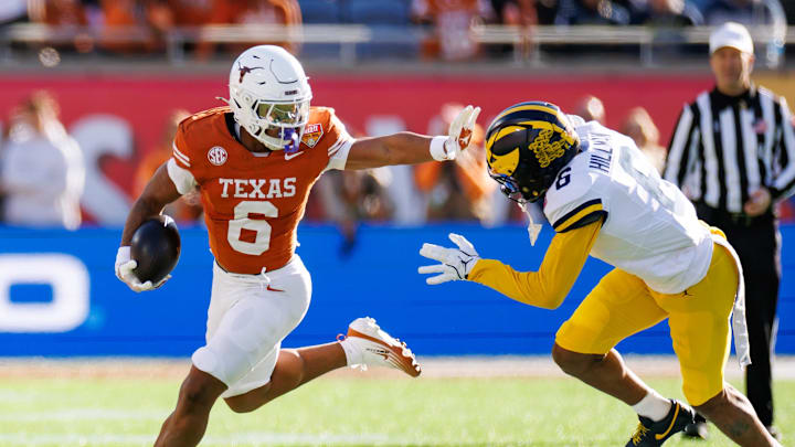 Dec 31, 2025; Orlando, FL, USA; Texas Longhorns running back Christian Clark (6) stiff arms Michigan Wolverines defensive back Brandyn Hillman (6) during the first half at Camping World Stadium. Mandatory Credit: Matt Pendleton-Imagn Images