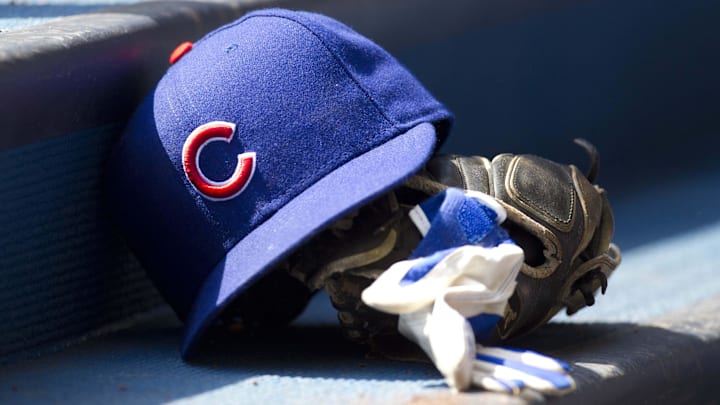 Chicago Cubs hat and glove in the dugout