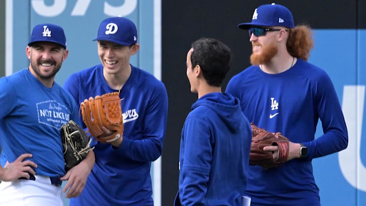 Dodgers relief pitcher Alex Vesia (51), starting pitcher Roki Sasaki (11), interpreter Will Ireton, and starting pitcher Dustin May (85) in the outfield up prior to the game against the Atlanta Braves at Dodger Stadium on March 31.
