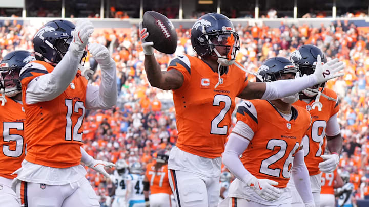 Oct 27, 2024; Denver, Colorado, USA; Denver Broncos cornerback Pat Surtain II (2) celebrates his interception with linebacker Kwon Alexander (12) and cornerback Riley Moss (21) and safety Devon Key (26) in the second half against the Carolina Panthers at Empower Field at Mile High. Mandatory Credit: Ron Chenoy-Imagn Images