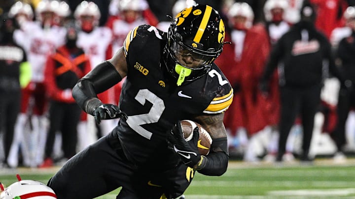 Nov 29, 2024; Iowa City, Iowa, USA; Iowa Hawkeyes running back Kaleb Johnson (2) runs the ball as Nebraska Cornhuskers defensive back Isaac Gifford (2) makes the tackle during the third quarter at Kinnick Stadium. Mandatory Credit: Jeffrey Becker-Imagn Images