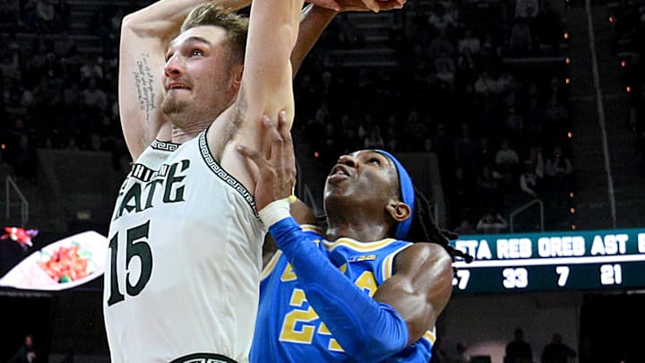 Feb 17, 2026; East Lansing, Michigan, USA; Michigan State Spartans center Carson Cooper (15) gets a flagrant foul call against UCLA Bruins center Steven Jamerson II (24) during the second half at Jack Breslin Student Events Center. Mandatory Credit: Dale Young-Imagn Images