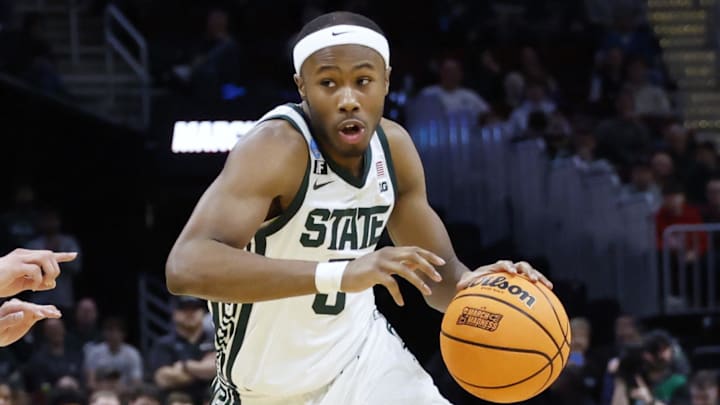 Mar 21, 2025; Cleveland, OH, USA; Michigan State Spartans guard Tre Holloman (5) dribbles defended by Bryant University Bulldogs guard Rafael Pinzon (24) in the second half during the NCAA Tournament First Round at Rocket Mortgage Fieldhouse. Mandatory Credit: Rick Osentoski-Imagn Images